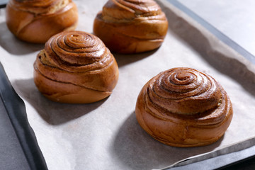 Sweet cinnamon rolls on baking tray