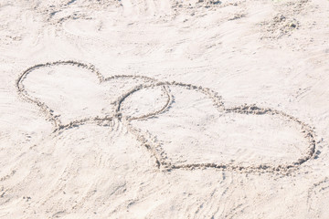 Drawing of hearts on sand. Beach wedding concept