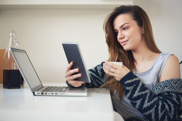 Fototapeta premium Student drinking coffee and using tablet in the morning