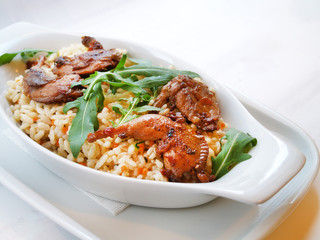 Fototapeta premium Quail with rice and creamy sauce, selective focus. Paella