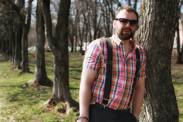 man beard suspender tree park sunglasses