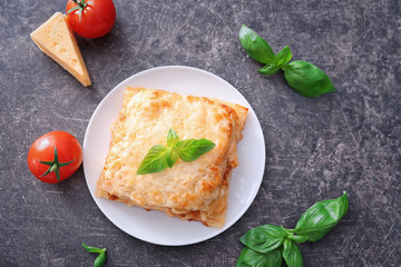 Fototapeta na wymiar Plate with tasty lasagna on grey background