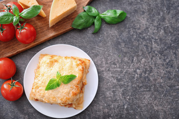 Plate with tasty lasagna on grey background