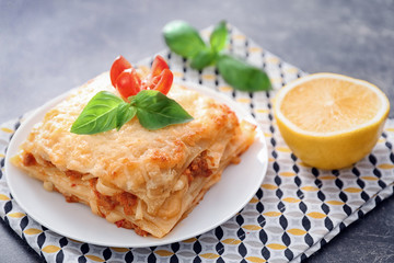 Plate with tasty lasagna on table