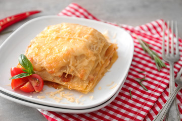 Plate with tasty lasagna on table