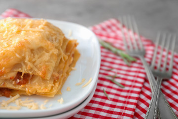 Plate with tasty lasagna on table, close up