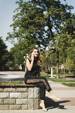 Young beautiful woman talking on the phone sitting in park