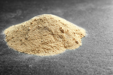 Heap of maca powder on dark  background