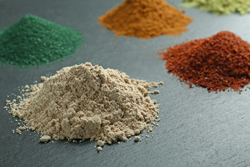 Various colorful superfood powders on grey background