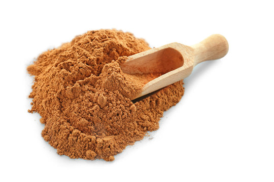 Pile of cumin spice and wooden scoop on white background