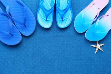 Fototapeta na wymiar Colorful flip flops on blue background