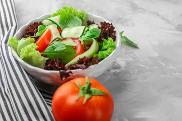 Delicious vegetable salad with cucumbers in bowl on table