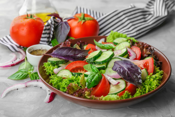 Delicious vegetable salad with cucumbers in bowl on table