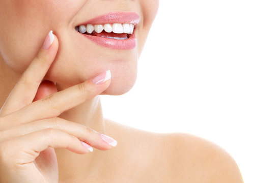 Closeup shot of beautiful female smile and manicured fingers, white background.