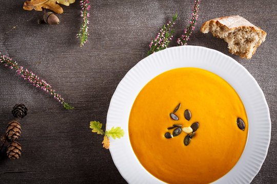 Autumn background scene of pumpkin soup with pumpkin seeds.