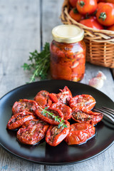 Bowl of sun dried tomatoes on wooden background. Sun dried tomatoes with olive oil and herbs