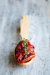 Bowl of sun dried tomatoes on wooden background. Sun dried tomatoes with olive oil and herbs