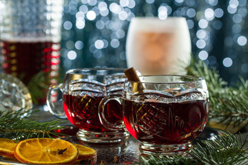 Hot mulled red wine on christmas table with bokeh light background.