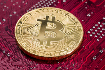 Goldene Bitcoin Münze auf einer Platine