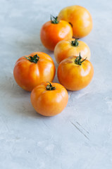 Yellow fresh ripe tomatoes on a white stone background. Overhead view and copy space.