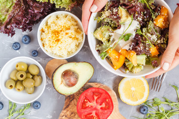 Bright colorful salad with couscous and vegetables, ingredients on the table, vegan lunch, top view.
