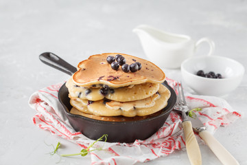 stack of blueberry pancakes (healthy vegan) with berries in a cast iron pan