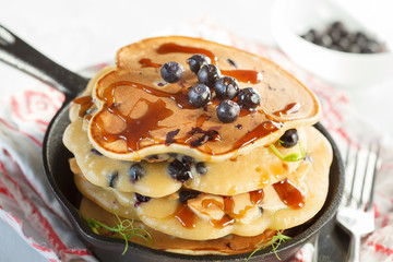 stack of blueberry pancakes (healthy vegan) with berries in a cast iron pan