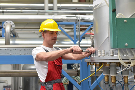 Monteur in einer Fabrik repariert technische  Industrieanlage // workman in a factory repaired technical industrial plant