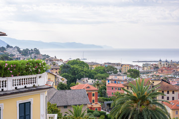 Fototapeta na wymiar Morning view from above to cloudy day in Santa Margherita Ligure city and sea in Italy. Balcony full of flowers.