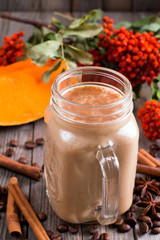 Pumpkin spiced latte or coffee in a glass on a table