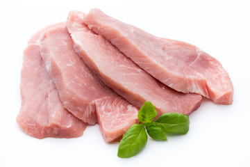 Fresh pork fillet with basil on a white background.