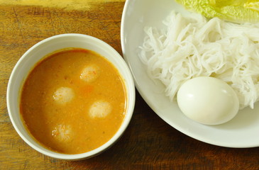 rice noodles and boiled egg eat couple with fish curry on bowl