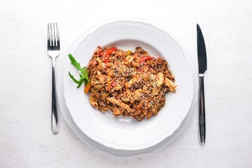 Chinese cuisine. Chicken fillet in tomato sauce on a wooden background. Top view. Free space for text.