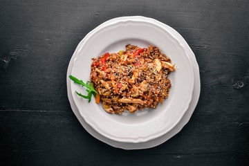 Chinese cuisine. Chicken fillet in tomato sauce on a wooden background. Top view. Free space for text.