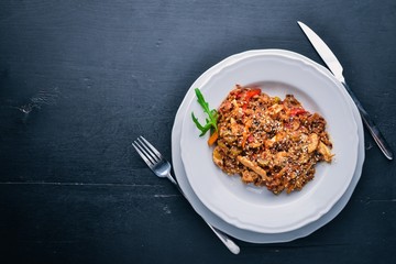 Chinese cuisine. Chicken fillet in tomato sauce on a wooden background. Top view. Free space for text.
