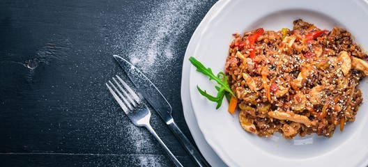 Chinese cuisine. Chicken fillet in tomato sauce on a wooden background. Top view. Free space for text.