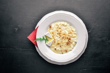 Risotto with cheese on a wooden background. Top view. Free space for text.