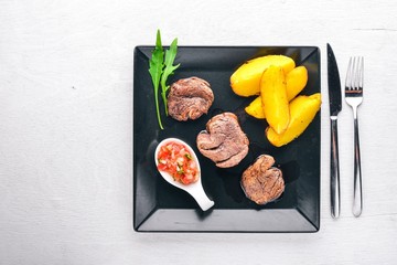 Veal medallions on a wooden background. Top view. Free space for text.