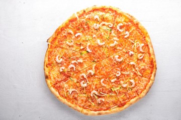 Pizza with shrimp. On a wooden background. Top view. Free space for text.