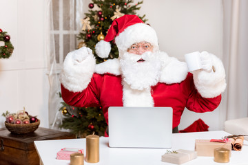 santa claus with laptop at home