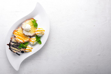 Biscuit pastry with caramel and chocolate sauce. On a wooden background. Top view. Free space for text.