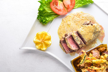 Veal steak and grilled vegetables. On a wooden background. Top view. Free space for text.