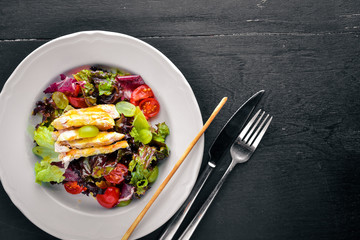 Vegetable salad with chicken and mango sauce on a wooden background. Top view. Free space for text.