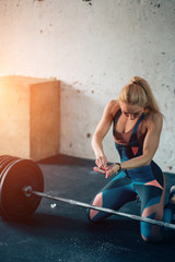 blonde woman exercising with barbell. girl preparing for weightlifting workout