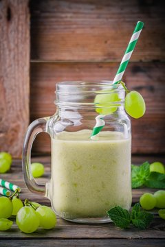 green organic detox grape smoothie in glass mason jar on  wooden background
