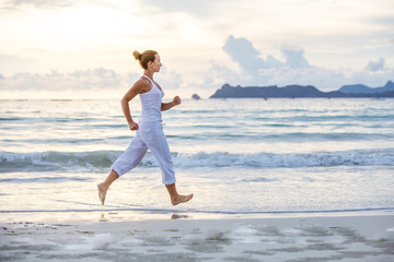 Kaukaska kobieta jogging przy seashore - 171159347