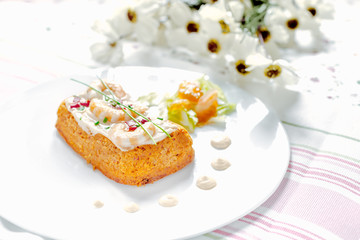 Traditional Spanish fish cake. Hake cake with tomato, shrimps and salad cream.
