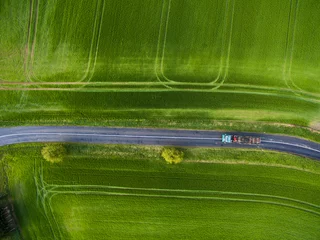 Fotobehang Luchtfoto Farmland from above - aerial image of a lush green filed  © lightpoet