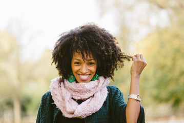Cheerful black woman with afro hair style in autumn at the park. © Dirima