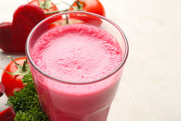 Glass with fresh vegetable juice and ingredients on table